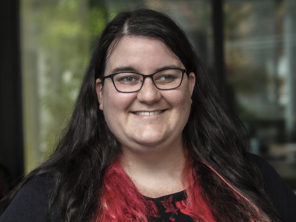 Das Foto zeigt die Wissenschaftlerin Danielle Pullan, Doktorandin an der IMPRS-SPCE. Das lange schwarze Haar tägt sie offen. Sie schaut lächelnd durch eine unauffällige Brille dem Betrachter entgegen.