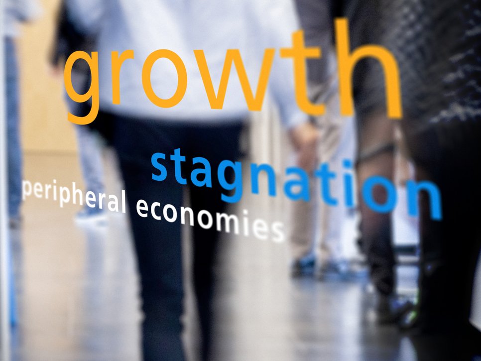Text displayed on a glass surface: "growth stagnation peripheral economies" with blurred figures walking in the background.