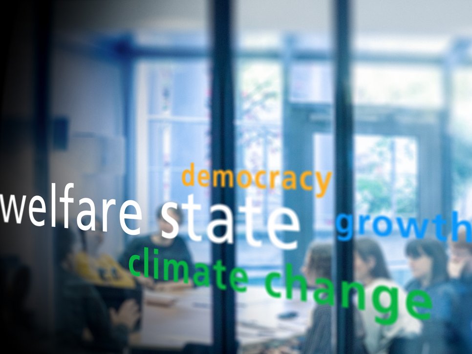 Various keywords such as "welfare state," "democracy," "climate change," and "growth" are projected onto a glass panel, with a meeting taking place in the background.
