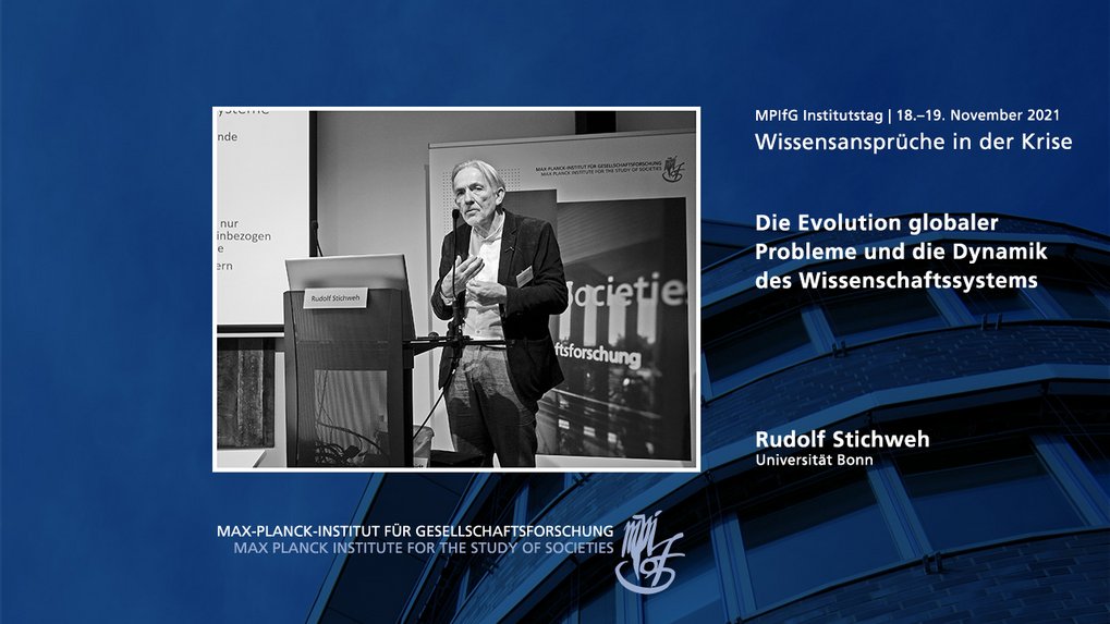 Das Bild zeigt einen Redner bei einer Konferenz mit einer Folie mit dem Titel „Die Evolution globaler Probleme und die Dynamik des Wissenschaftssystems“. Der Redner ist Rudolf Stichweh von der Universität Bonn, und die Veranstaltung ist Teil des Max-Planck-Instituts für Gesellschaftsforschung, das vom 18. bis 19. November 2021 stattfand.