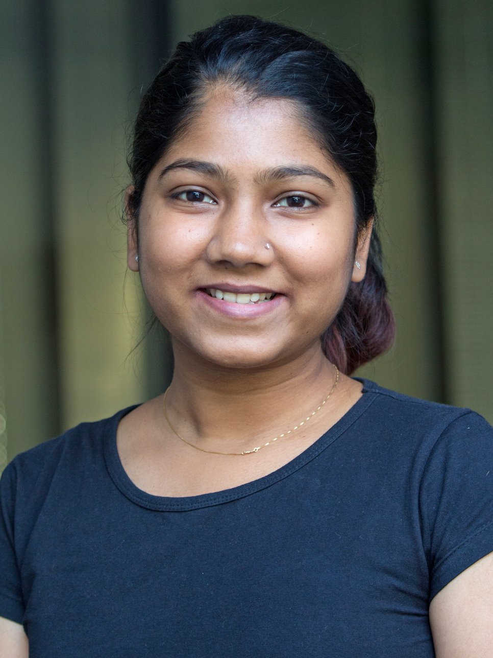 Das Porträt-Foto zeigt die junge Wissenschaftlerin Sandhya A.S., die im August an der Universität Duisburg-Essen promoviert worden ist. Sie lächelt freudig, vermutlich im emotionalen Auftrieb ob der gelungenen Lebensleistung.
