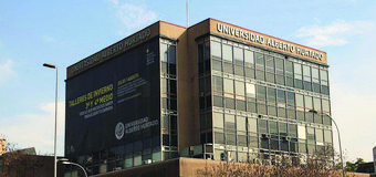 Universidad Alberto Hurtado's building featuring a prominent banner promoting winter workshops for July and August.