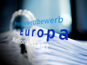 The image features the words "Regimewettbewerb," "Europa," and "Nationalstaat" in varying font sizes against a blue, blurred background, possibly implying political or economic themes within Europe.