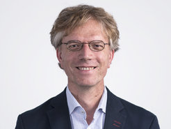 Auf dem Foto ist Werner Eichhorst zu erkennen, Arbeitsmarktwissenschaftler und über viele Jahre eng mit dem MPIfG verbunden. Kurzes, volles Haar, Brille, Hemd und Sakko vermitteln Frische und Tatendrang. Das Lächeln drückt echte Sympathie aus.