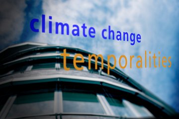 Blurred building facade with reflective glass panels, set against a partly cloudy sky, featuring text "climate change temporalities" in blue and orange.
