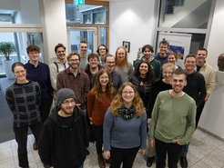 Das Foto zeigt jüngere Exemplare der Gattung Homo sapiens intellectualis, versammelt zu einem Gruppenfoto im Foyer des MPIfG anlässlich ihres Interessebesuches am Institut.