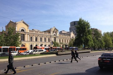 The photo is a shot of the Universidad de Chile (UCEN), with which MPIfG has signed a new cooperation agreement. A yellow, historic building with classic architecture along a busy street with buses, cars, and pedestrians, surrounded by trees and modern buildings in the background. Das Foto wurde an der Universität von Chile (UCEN) aufgenommen, mit der das MPIfG eine neue Kooperationsvereinbarung unterzeichnet hat.