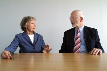 Fritz W. Scharpfs Arbeiten strahlen in hohem Maße in Nachbardisziplinen aus, seine Analysen werden in Soziologie, Wirtschaftswissenschaften und Rechtswissenschaften rezipiert. Interdisziplinär angelegt war auch die Zusammenarbeit mit der Soziologin und Ko-Direktorin am MPIfG Renate Mayntz. Gemeinsam entwickelten sie in den 1980er- und 1990er-Jahren die theoretischen Grundlagen des akteurzentrierten Institutionalismus. Dieser Ansatz, der die Wechselwirkungen zwischen institutionellen Strukturen und dem strategischen Handeln politischer Akteure in das Zentrum des Interesses rückt, wurde zu einem Meilenstein der soziologischen wie politikwissenschaftlichen Steuerungs- und Governance-Forschung. Eine Frau in blauem Blazer gestikuliert, während sie neben einem Mann mit gestreifter Krawatte an einem Holztisch sitzt.