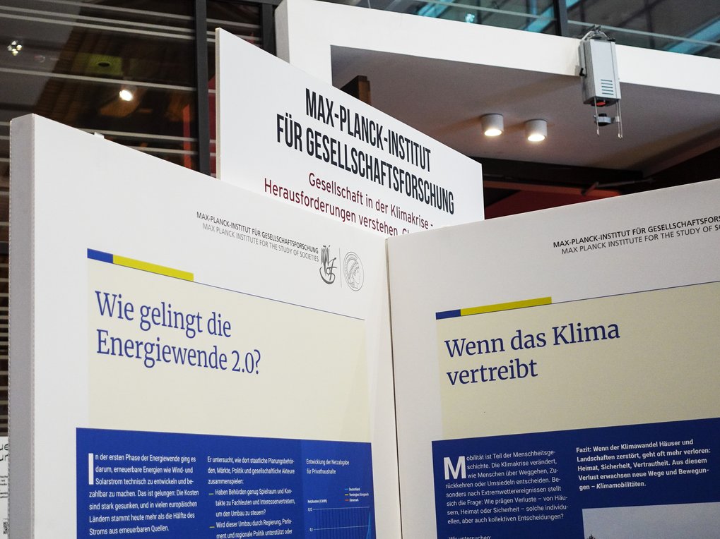 Display panels at the Max Planck Institute for the Study of Societies discuss societal challenges in the climate crisis, focusing on energy transition and climate migration.