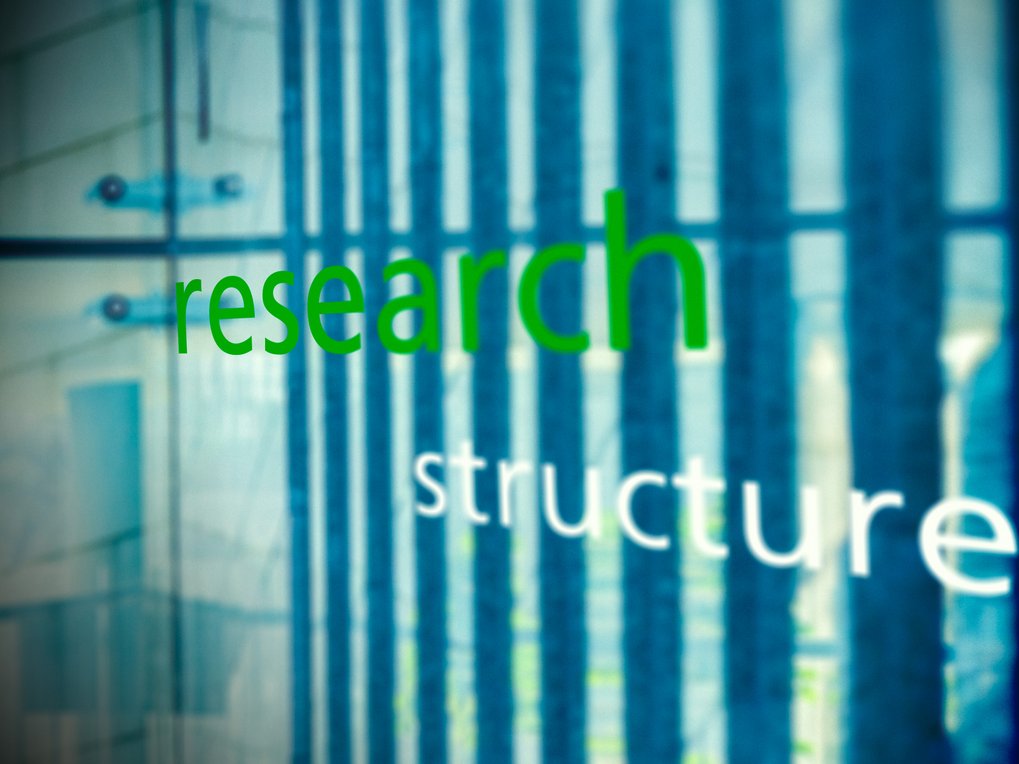 The words "research" in green and "structure" in white appear on a glass surface with blue vertical stripes in the background.