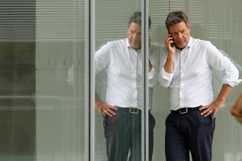 © picture alliance/Flashpic | Jens Krick Robert Habeck telefoniert mit ernster Miene vor einer verspiegelten Fläche