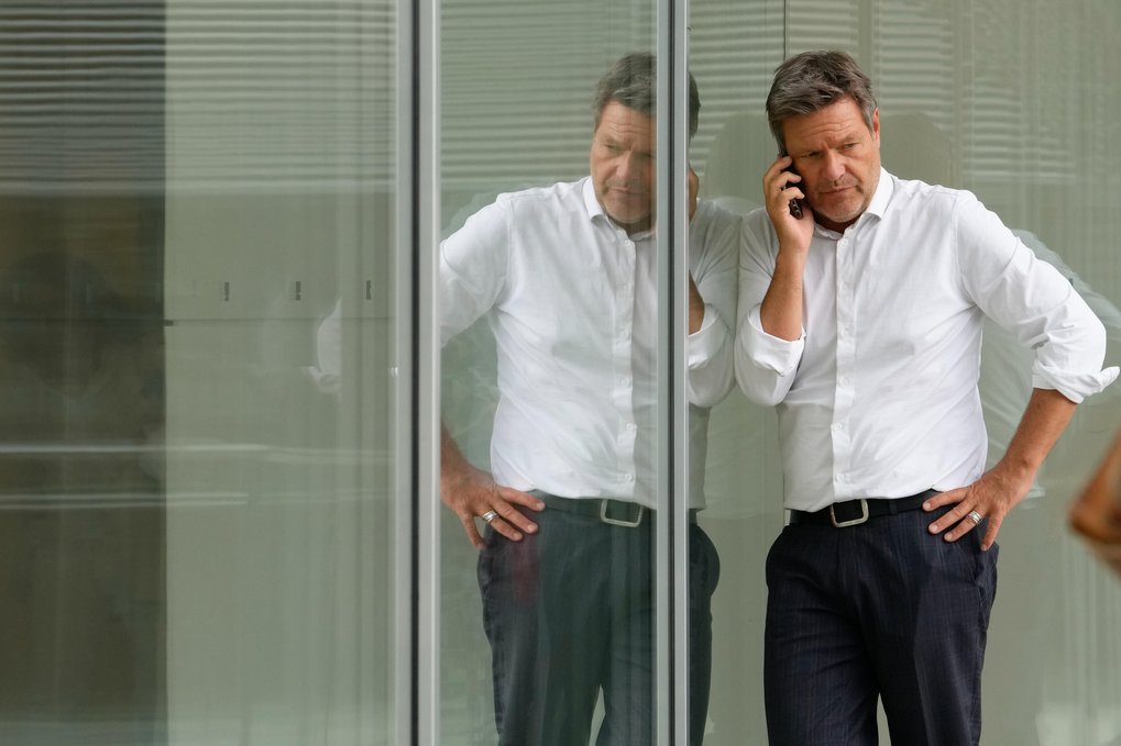 Robert Habeck telefoniert mit ernster Miene vor einer verspiegelten Fläche