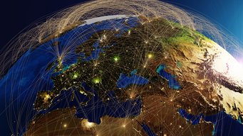 A satellite view of Earth showing cities connected by glowing lines that represent communication or transportation links.