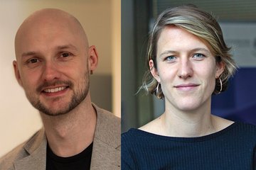 Zwei Personen, ein Mann mit hellgrauem Sakko und eine Frau mit schwarzem Oberteil und kurzen blonden Haaren, frontal aufgenommen vor unscharfem Hintergrund.