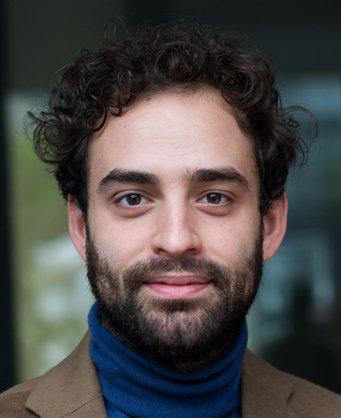 Donato Di Carlo ist Max Weber Fellow 2020/21 am EUI Porträt eines Individuums aller Wahrscheinlichkeit männlicher Art mit dunklen Augen. Es hat schwarz gelocktes, kurzes Haar, einen ebensolchen schwarzen Bart. Der blaue Rollkragenpullover umgreift den Hals lückenlos. Das feine Sakko ist braun gefärbt.