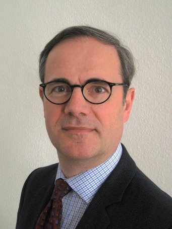 Bernhard Ebbinghaus, Professor of Social Policy and Senior Research Fellow of Green Templeton College at University of Oxford Grauer Anzug mit einem karierten Hemd und einer gemusterten Krawatte, vor einer hellen Wand.