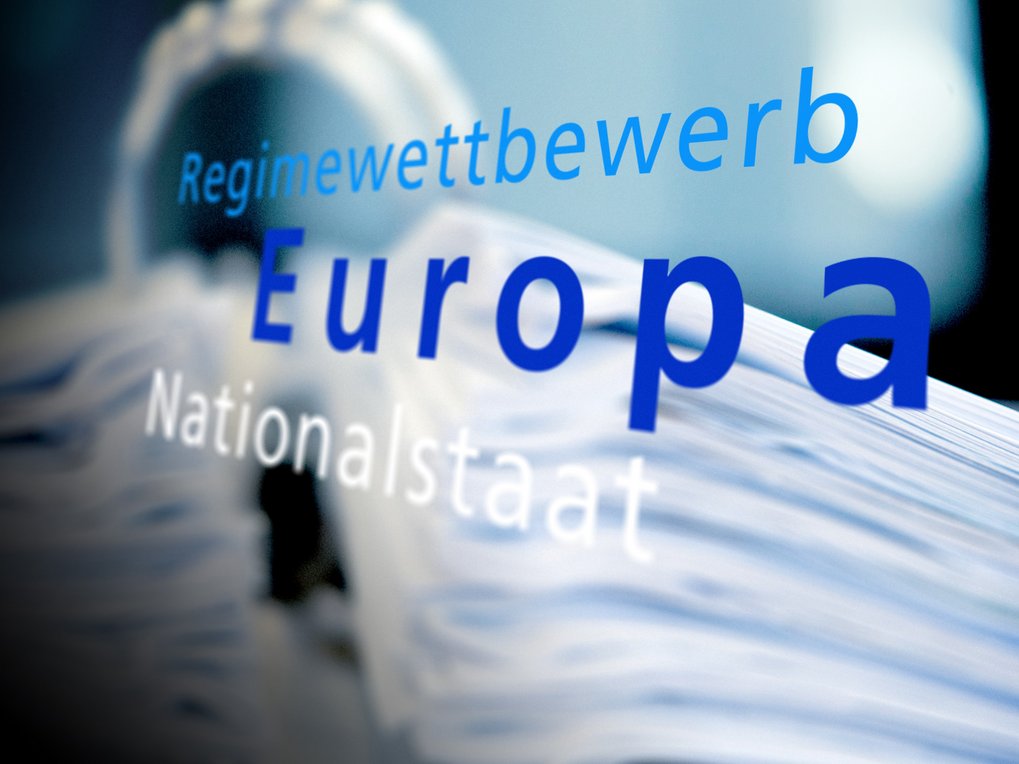Begriffe "Regimewettbewerb", "Europa" und "Nationalstaat" in blauer Schrift, vor einem verschwommenen, weißen Hintergrund.