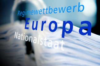Begriffe "Regimewettbewerb", "Europa" und "Nationalstaat" in blauer Schrift, vor einem verschwommenen, weißen Hintergrund.