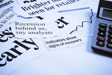 A collection of newspaper clippings highlights economic recovery, featuring headlines on recession and recovery indicators, alongside a calculator and graph.