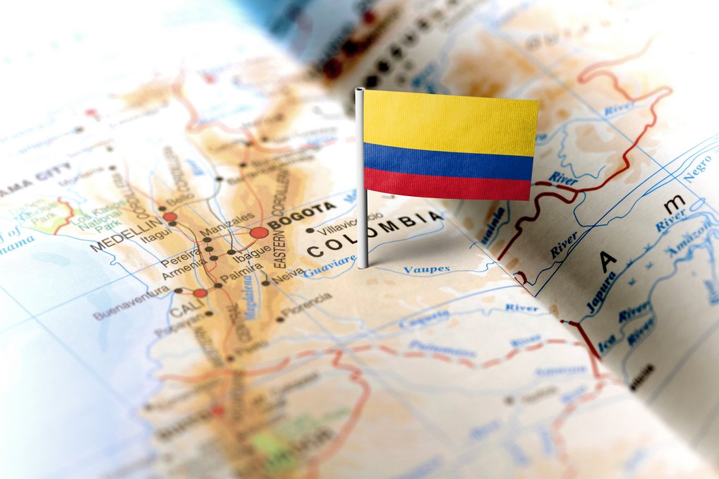 Colombian flag pin marking location on map, highlighting cities Bogotá and Medellín amidst geographical details.