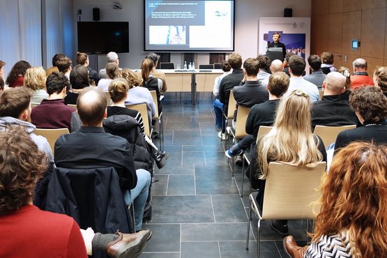 Konferenzraum mit einer Sprecherin vor Publikum
